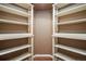 Walk-in closet with custom shelving, hardwood floor and painted in neutral colors at 7370 S Catawba Way, Aurora, CO 80016