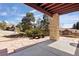 Covered back patio with stone columns offers views of mature trees and landscaped backyard at 7370 S Catawba Way, Aurora, CO 80016