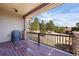 Relaxing covered porch featuring wood flooring and railing, stone columns, and a view of the backyard at 7370 S Catawba Way, Aurora, CO 80016