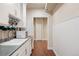 Hallway features wainscoting, wood floors, white cabinets, sink and microwave at 7370 S Catawba Way, Aurora, CO 80016