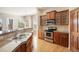 Kitchen features stainless steel appliances, granite countertops, hardwood floors, and wood cabinets at 7370 S Catawba Way, Aurora, CO 80016