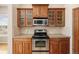 Kitchen features stainless steel appliances, tile backsplash, wood cabinets, and granite countertops at 7370 S Catawba Way, Aurora, CO 80016