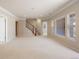 Large living room features staircase, large windows, and neutral carpet at 7370 S Catawba Way, Aurora, CO 80016