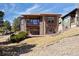 Spacious two-story rear exterior with stone accents, large windows, and walkout patio spaces at 7370 S Catawba Way, Aurora, CO 80016