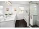 Modern bathroom with black honeycomb floors, white subway tiles, double vanity, and glass enclosed shower at 1047 Uinta Way, Denver, CO 80230