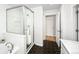 Bright bathroom with black honeycomb floors, a glass-enclosed shower, and a separate bathtub at 1047 Uinta Way, Denver, CO 80230