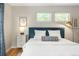 Well-lit bedroom with a blue upholstered headboard, white linens, and two large windows at 1047 Uinta Way, Denver, CO 80230