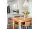 Cozy dining area with wood table, leather chairs, chandelier, and adjacent kitchen with white cabinetry at 1047 Uinta Way, Denver, CO 80230