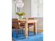 Bright dining room with wood table, brown chairs, and a stylish chandelier over a blue rug at 1047 Uinta Way, Denver, CO 80230