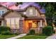 Inviting front exterior featuring a brick facade, covered porch with hanging plants, and a well-maintained lawn at 1047 Uinta Way, Denver, CO 80230