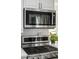 A close up of a modern stainless steel KitchenAid microwave over a stovetop with white cabinets at 1047 Uinta Way, Denver, CO 80230