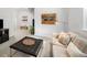 Comfortable living room featuring a soft sofa, tufted ottoman, and stylish decor creating a cozy and inviting atmosphere at 1047 Uinta Way, Denver, CO 80230