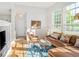 Bright living room with hardwood floors, a comfortable sectional, and large windows, creating a warm and inviting space at 1047 Uinta Way, Denver, CO 80230