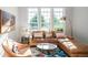Sunlit living room with a leather sectional, decorative rug, and large windows offering scenic views at 1047 Uinta Way, Denver, CO 80230