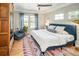 Spacious bedroom with a ceiling fan, hardwood floors, large windows, and a colorful rug at 1047 Uinta Way, Denver, CO 80230