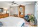 Bright bedroom with an antique armoire, wood floors, and a cozy seating area by the window at 1047 Uinta Way, Denver, CO 80230