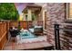 Inviting outdoor patio featuring comfortable seating, string lights, and a well-maintained brick surround at 1047 Uinta Way, Denver, CO 80230