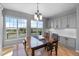 Bright dining room featuring a dark wood table set, hardwood floors, and large windows with neighborhood views at 11703 S Rock Willow Way, Parker, CO 80134