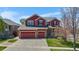 Charming two-story home with a three car garage, stone accents, and a well-manicured lawn at 11703 S Rock Willow Way, Parker, CO 80134