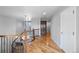 Upstairs hallway displaying wood floors, chandelier, decorative railing, and a storage closet at 11703 S Rock Willow Way, Parker, CO 80134