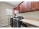 Functional laundry room with overhead cabinets, folding area, and modern washer and dryer at 11703 S Rock Willow Way, Parker, CO 80134