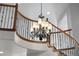 Close up of elegant curved staircase with wooden banister and decorative chandelier at 11703 S Rock Willow Way, Parker, CO 80134