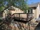 Backyard area with a wooden deck, garden beds, and mature trees at 21444 E Lehigh Ave, Aurora, CO 80013