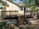 Backyard deck with stairs, small garden beds, and mature trees at 21444 E Lehigh Ave, Aurora, CO 80013