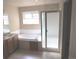 Bright bathroom featuring a soaking tub, glass-enclosed shower, and large window at 21444 E Lehigh Ave, Aurora, CO 80013
