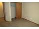 Bedroom with neutral carpet, trim and walls, featuring closet with sliding doors at 21444 E Lehigh Ave, Aurora, CO 80013