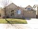 Charming two-story home featuring a stone facade, a well-manicured lawn, and an attached two-car garage at 21444 E Lehigh Ave, Aurora, CO 80013