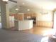 Open kitchen with wood cabinets, center island, hardwood floors, and seamless flow to living areas at 21444 E Lehigh Ave, Aurora, CO 80013
