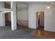 Open living area with modern support beams, neutral paint, hardwood accents and access to a bathroom at 21444 E Lehigh Ave, Aurora, CO 80013