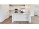 Bright kitchen features white cabinets, stainless appliances, and a large center island at 587 Nightsky St, Erie, CO 80516