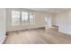 Open living area with wood flooring, three windows, and slider door at 587 Nightsky St, Erie, CO 80516