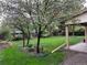 Lush green backyard with flowering trees and manicured landscaping surrounding the property at 710 S Grand Ave, Fort Lupton, CO 80621