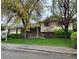 Charming brick and siding home with mature landscaping and a cozy front patio area at 710 S Grand Ave, Fort Lupton, CO 80621