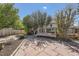 Flagstone patio leads to a small stained wooden deck, accented by surrounding landscape and a wooden fence at 5400 S Quail Way, Littleton, CO 80127