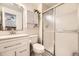 Modern bathroom featuring a glass-enclosed shower, a sleek vanity, and a view to the bedroom at 5400 S Quail Way, Littleton, CO 80127