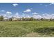 A view across a lush green field, framed by neighborhood homes and a bright, cloudy sky at 5400 S Quail Way, Littleton, CO 80127