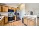 A well-lit kitchen with stainless steel appliances and wooden cabinets offers modern convenience and ample storage at 5400 S Quail Way, Littleton, CO 80127