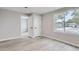 Bright and airy bedroom showcasing fresh paint, modern flooring, and a large window overlooking the front yard at 6880 Pontiac St, Commerce City, CO 80022
