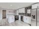 Modern kitchen featuring stainless steel appliances, white cabinets, and a stylish black and white backsplash at 6880 Pontiac St, Commerce City, CO 80022