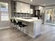Bright and modern kitchen boasting stainless steel appliances, eat-in island, and stylish black and white backsplash at 6880 Pontiac St, Commerce City, CO 80022