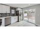Well-lit kitchen featuring stainless steel appliances, elegant backsplash, and a sliding glass door to the backyard at 6880 Pontiac St, Commerce City, CO 80022