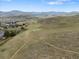 Scenic aerial view of property showcasing vast land, walking trails, and distant mountain views at 19093 W 61St Pl, Golden, CO 80403