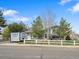 Charming two-story home with a well-maintained lawn, white picket fence, and mature trees at 19093 W 61St Pl, Golden, CO 80403