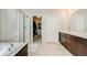 Bathroom with glass shower and double vanity with dark cabinets, with access to walk-in closet at 12677 Fisher Dr, Englewood, CO 80112