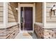 Inviting entryway features a rich wood door framed by stone accents and classic exterior lighting at 12677 Fisher Dr, Englewood, CO 80112