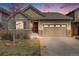 Charming home featuring stone accents, a two-car garage, and manicured lawn, set against a vivid sunset sky at 12677 Fisher Dr, Englewood, CO 80112